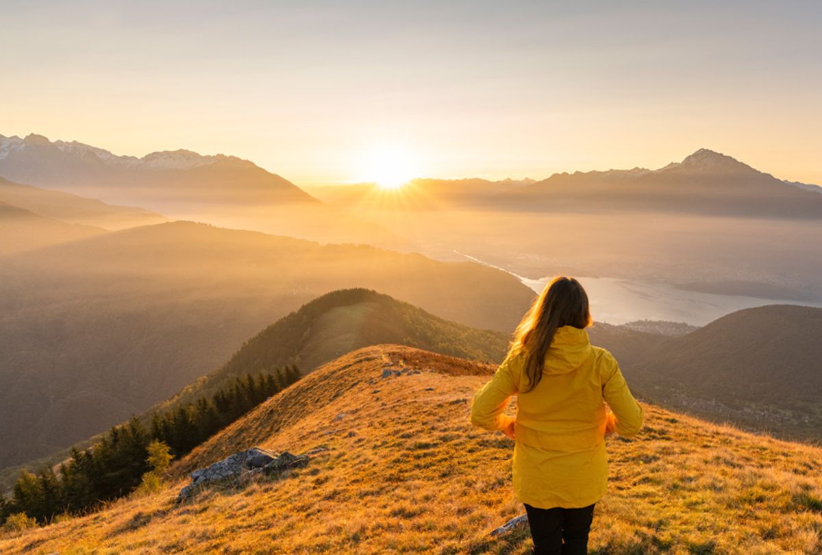 Rear view of woman with yellow jacket gazing at mountains and northern branch of Lake Como at dawn. Peglio, Como province, Lombardy region, Italy. (Getty/Francesco Vaninetti Photo)