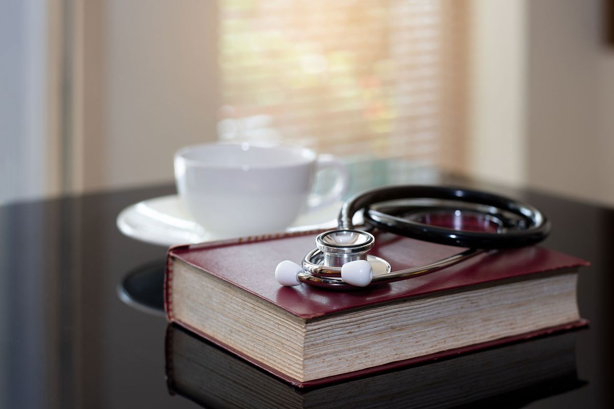 Desk with a medical stethoscope, a book and a cup of coffee (iStock/Getty Images)