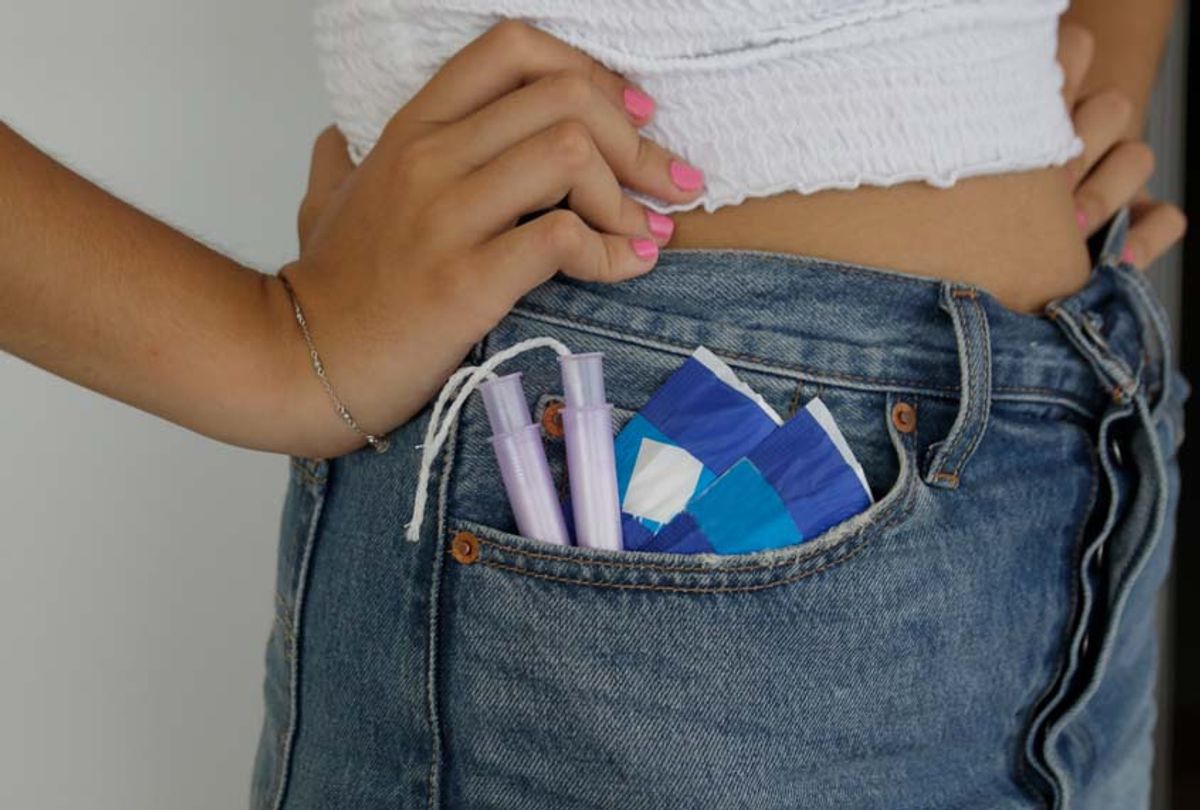 Girl with sanitary pads and tampons in pocket (Getty/Isabel Pavia)