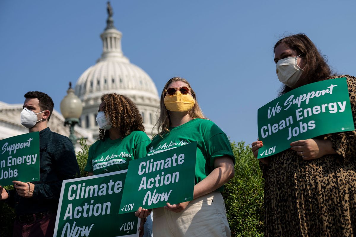 Activists look on as Senate Majority Leader Chuck Schumer (D-NY) speaks during a news conference about climate change outside the U.S. Capitol on July 28, 2021 in Washington, DC. (Drew Angerer/Getty Images)