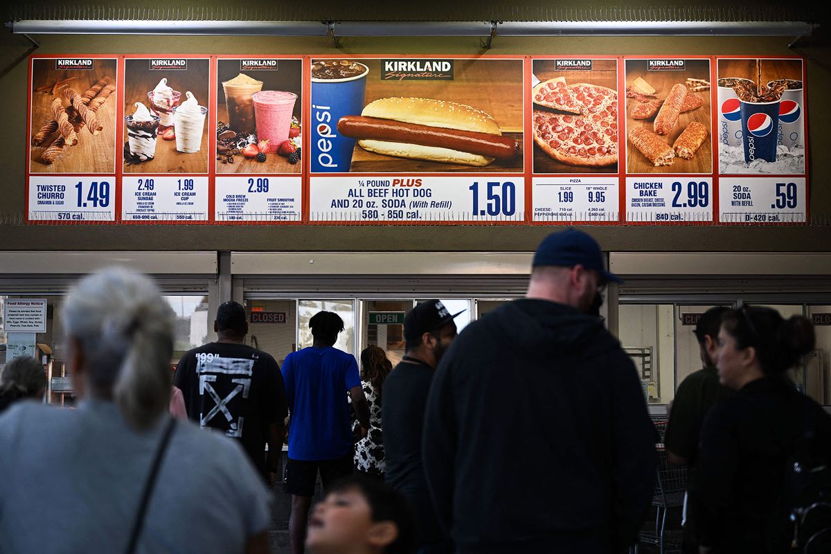 Customers wait in line to order below signage for the Costco Kirkland Signature $1.50 hot dog and soda combo at the food court outside a Costco Wholesale store in Hawthorne, California. (PATRICK T. FALLON/AFP via Getty Images)