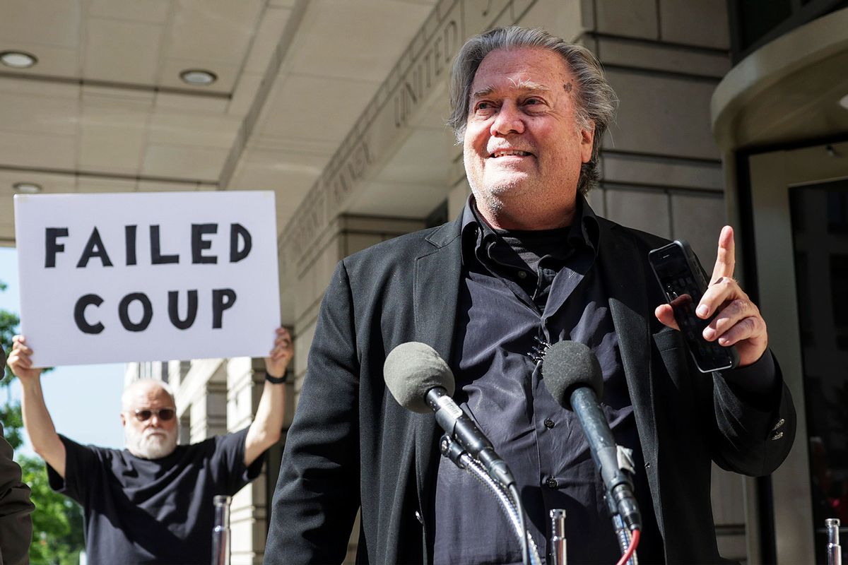 Steve Bannon, advisor to former President Donald Trump, speaks to the media as a protester stands behind him, outside of the E. Barrett Prettyman U.S. Courthouse on June 15, 2022 in Washington, DC. (Kevin Dietsch/Getty Images)