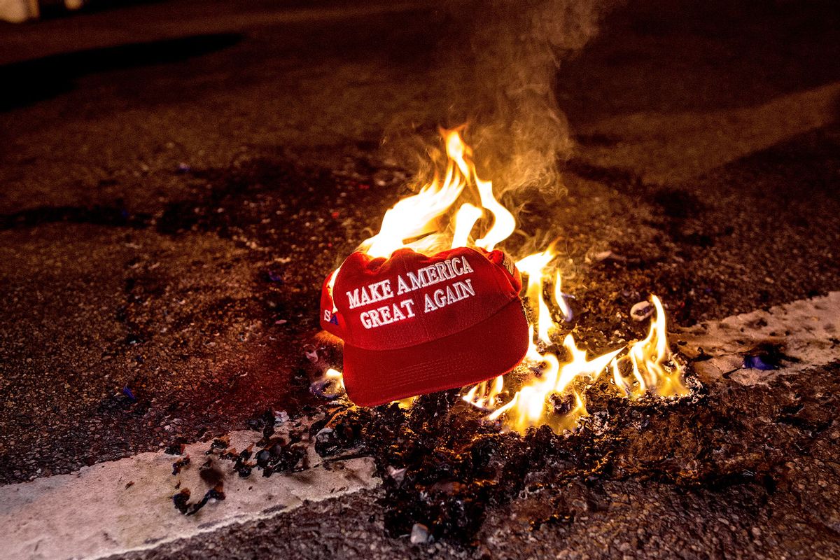 MAGA hat burning in the street (Probal Rashid/LightRocket via Getty Images)