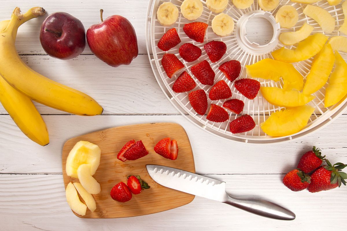 A Tray of Fruit Being Prepared to Dehydrate on a Wooden Table (Getty Images/pamela_d_mcadams)