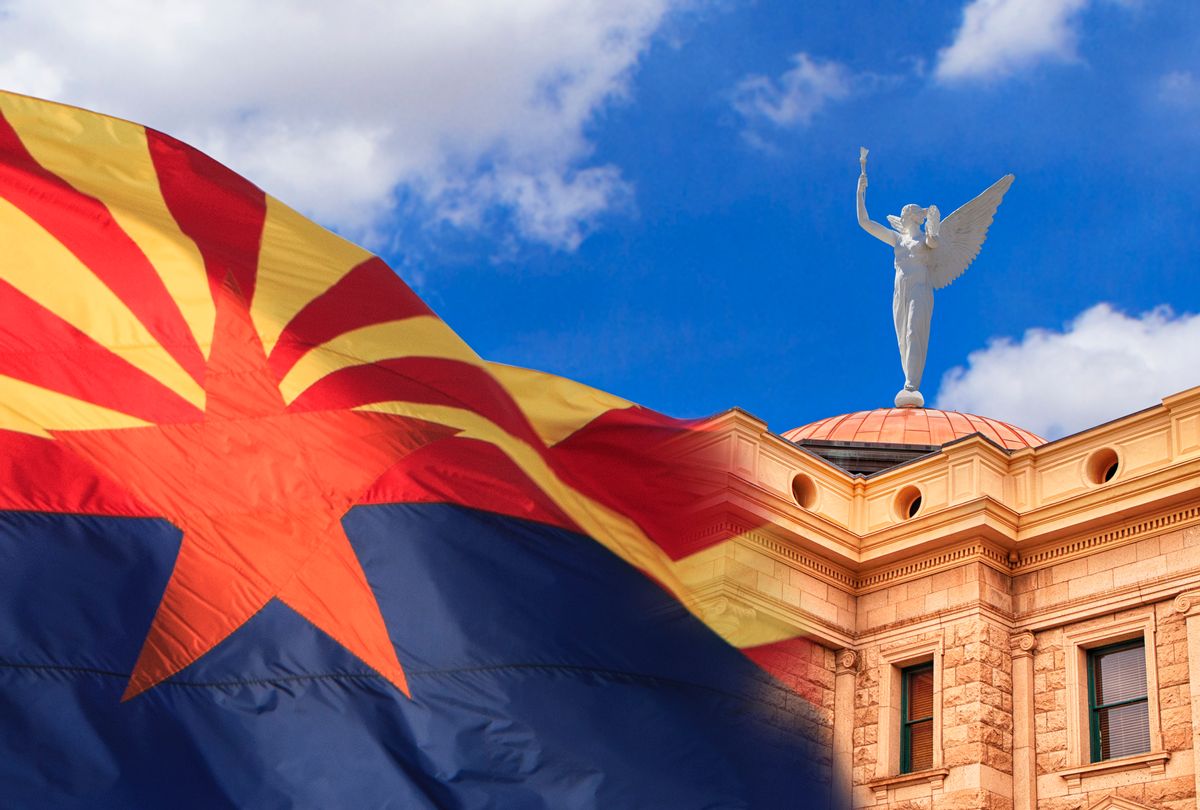 Arizona state capitol building in Phoenix, with wind blowing the state flag outside. Winged Goddess of Victory, Statue of Justice weather vane stands on top of the Capitol's copper dome. (Getty Images / DustyPixel)