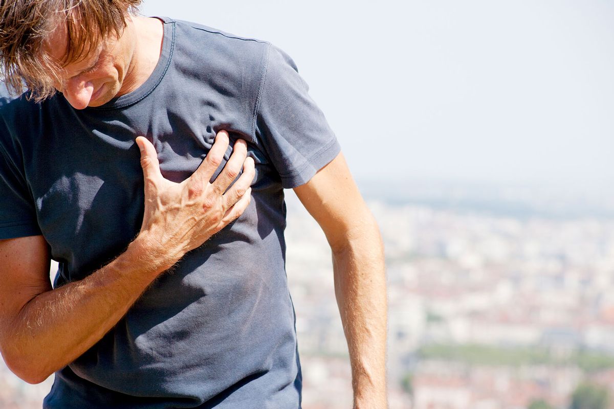 A male person clutching chest in pain (Getty Images/Jan-Otto)