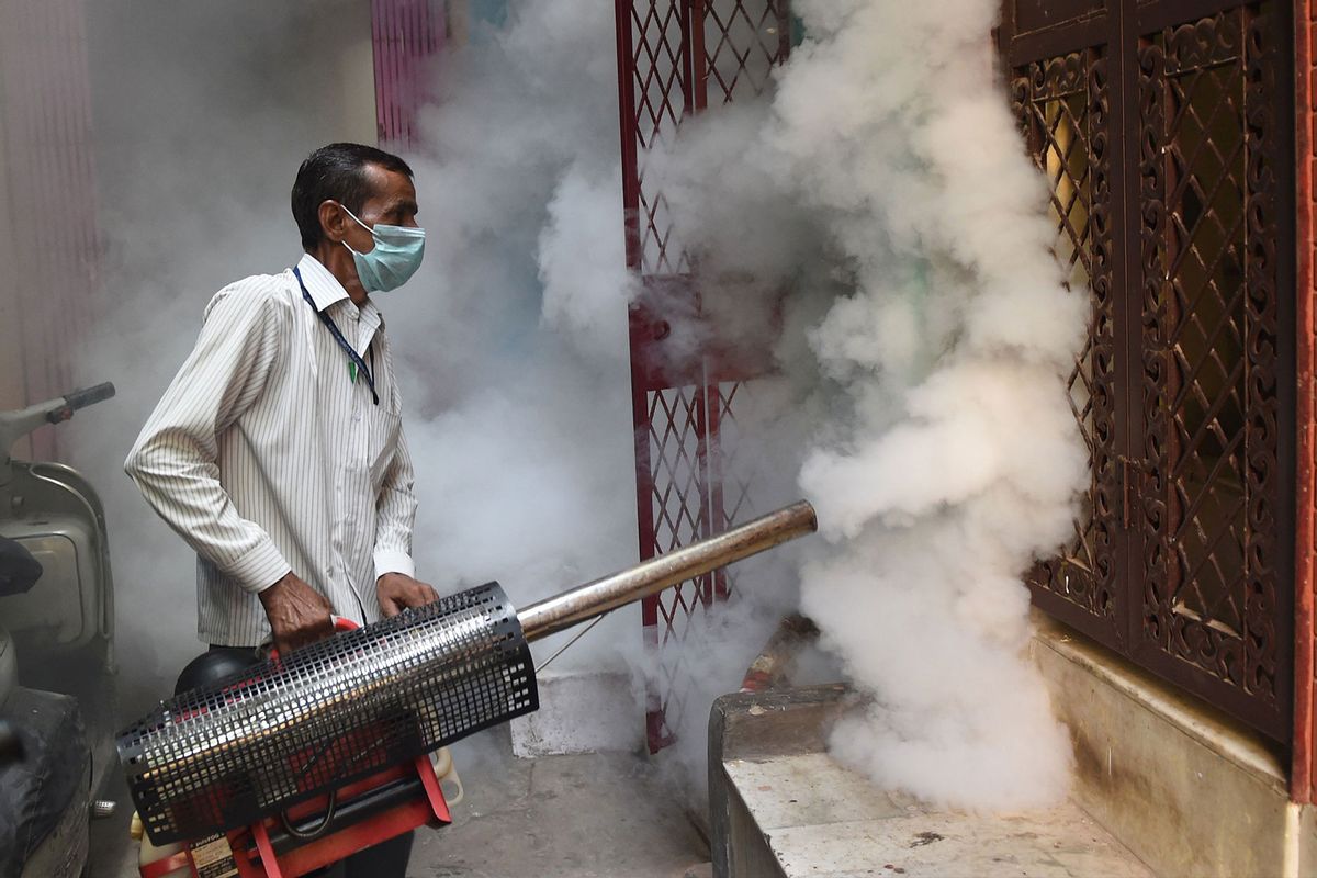 A Municipal Corporation of Delhi (MCD) worker fumigates an area to prevent mosquitos from breeding in New Delhi. (PRAKASH SINGH/AFP via Getty Images)