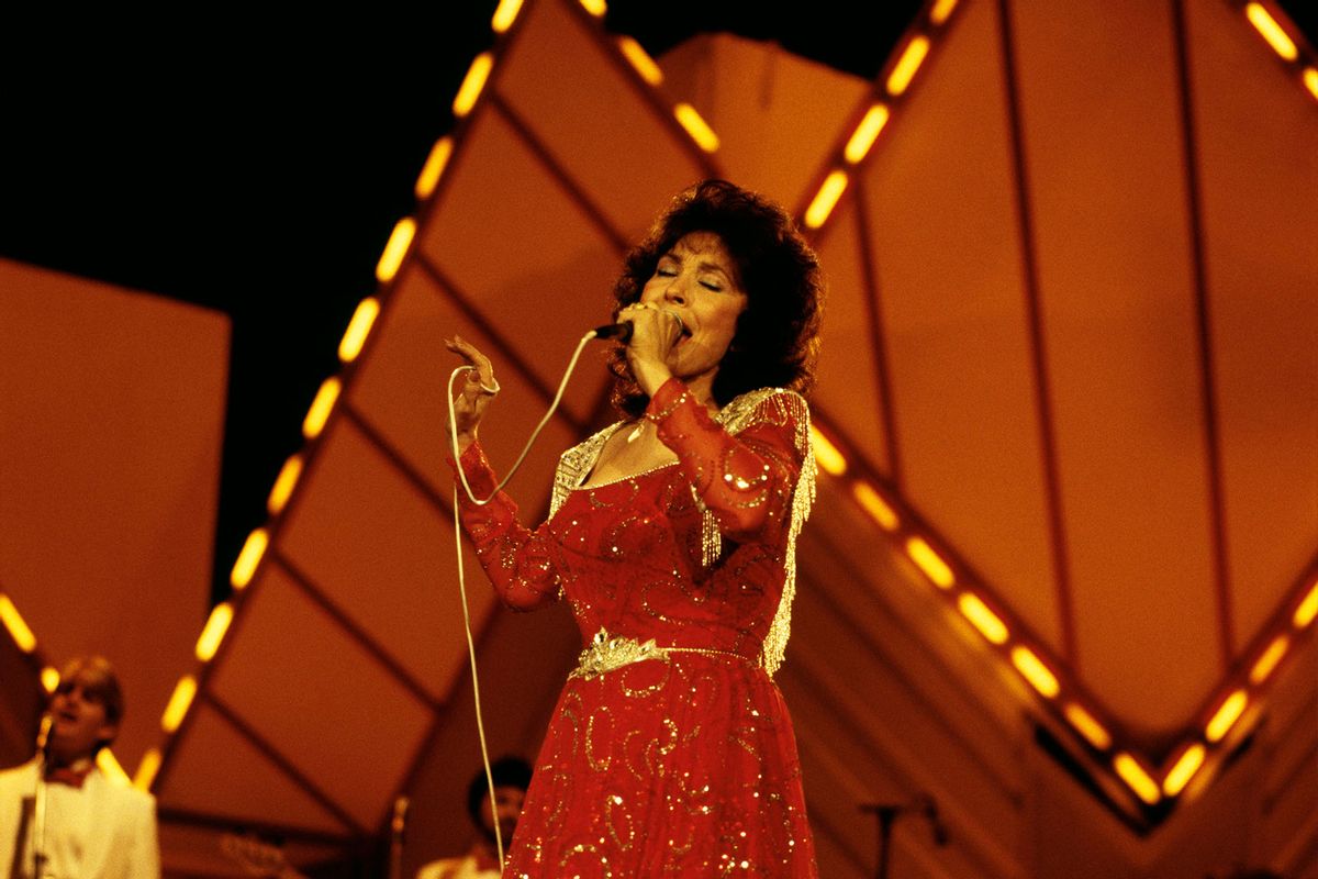 Loretta Lynn performing on stage (David Redfern/Redferns/Getty Images)