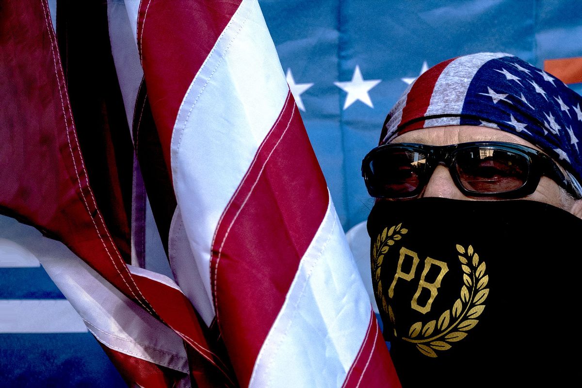 A member of the Proud Boys holds a US national flag during a rally against gender-affirming care by Vanderbilt University Medical Center, at the War Memorial Plaza in Nashville, Tennessee, on October 21, 2022. (SETH HERALD/AFP via Getty Images)