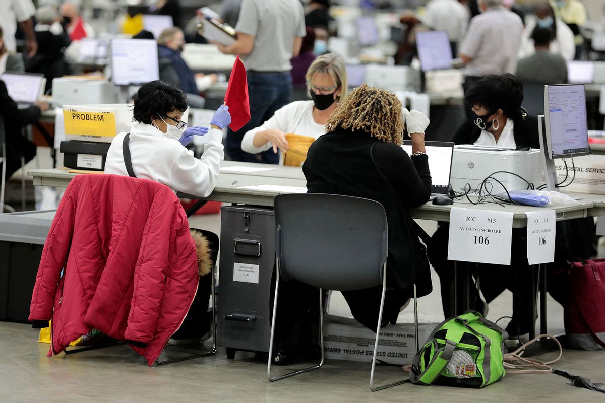 An election worker holds up a red flag to ask for help while presorting absentee ballots cast in the city of Detroit during the 2022 general election at Huntington Place in Detroit, Michigan on November 6, 2022. (JEFF KOWALSKY/AFP via Getty Images)