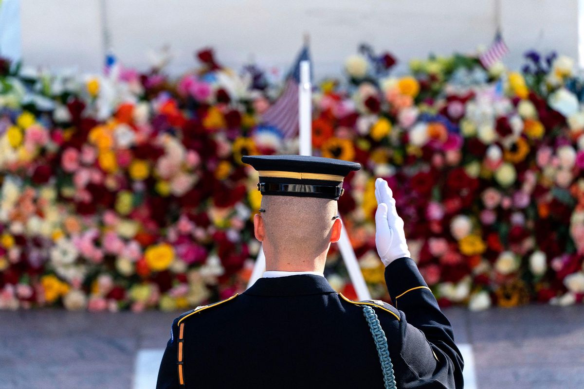 A tomb guard of the 3rd US Infantry Regiment, known as "The Old Guard," salutes before a centennial ceremony for the Tomb of the Unknown Soldier, in Arlington National Cemetery, on Veterans Day in Arlington, Virginia, on November 11, 2021. (ALEX BRANDON/POOL/AFP via Getty Images)