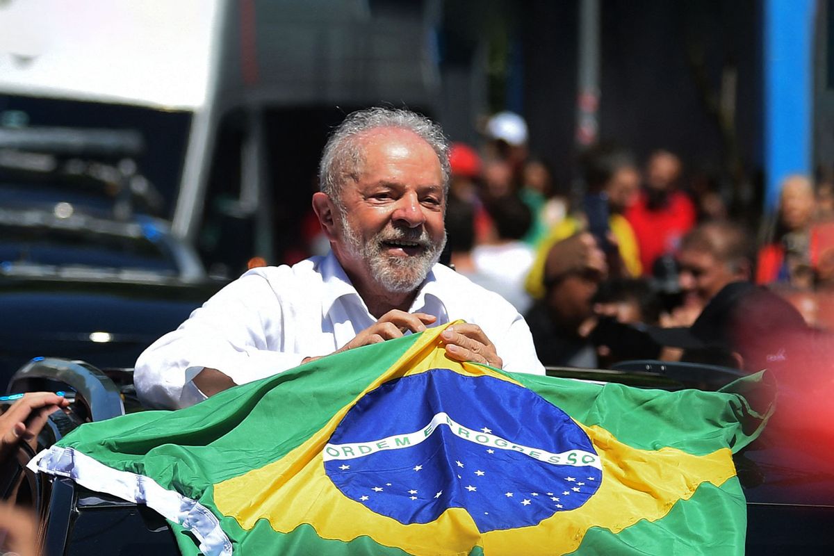 Brazilian former President (2003-2010) and candidate for the leftist Workers Party (PT) Luiz Inacio Lula da Silva holds a Brazilian flag while leaving a polling station during the presidential run-off election, in Sao Paulo, Brazil, on October 30, 2022. (CARL DE SOUZA/AFP via Getty Images)