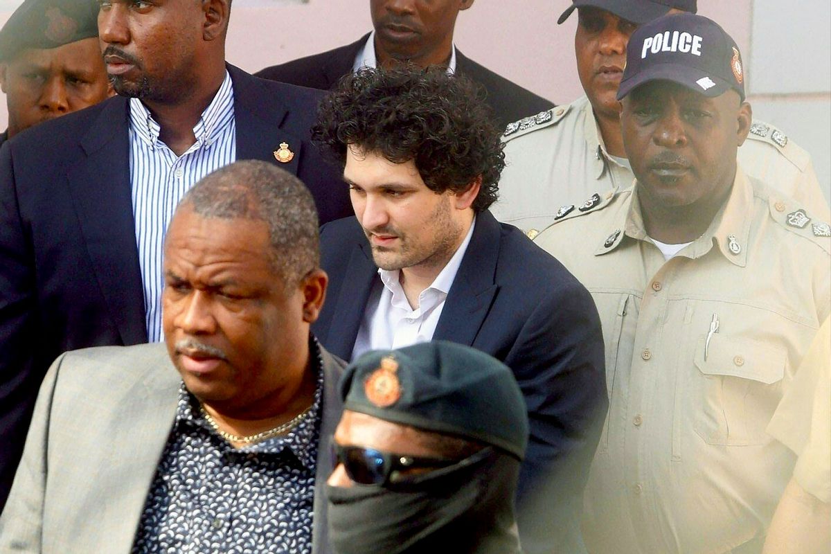 FTX founder Sam Bankman-Fried (C) is led away handcuffed by officers of the Royal Bahamas Police Force at the Nassau, Bahamas, courthouse on December 19, 2022. (KRIS INGRAHAM/AFP via Getty Images)