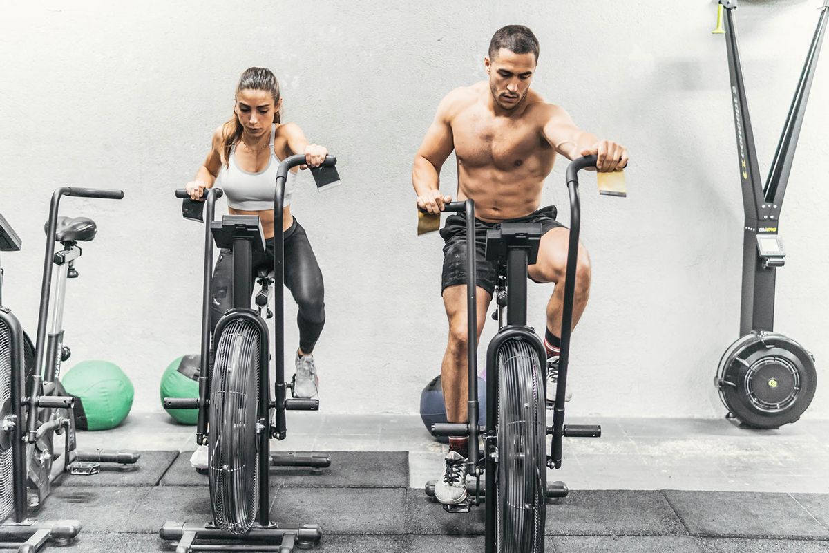 Couple using the stationary bikes in the gym (Getty Images/Cavan Images)