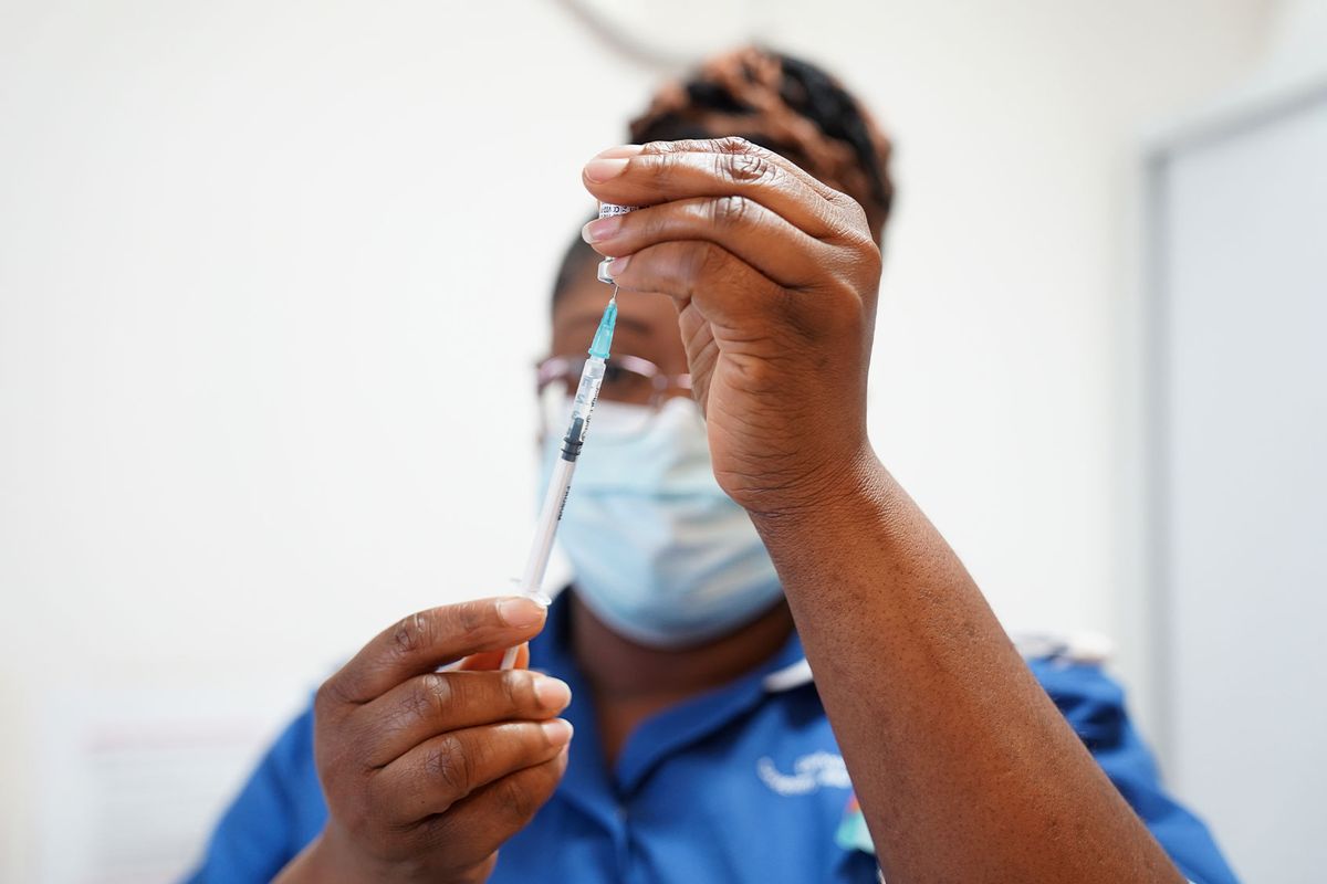 A nurse prepares a dose of a Covid-19 vaccine for a patient at University Hospital Coventry on April 22, 2022 in Coventry, England. (Jacob King - WPA Pool / Getty Images)