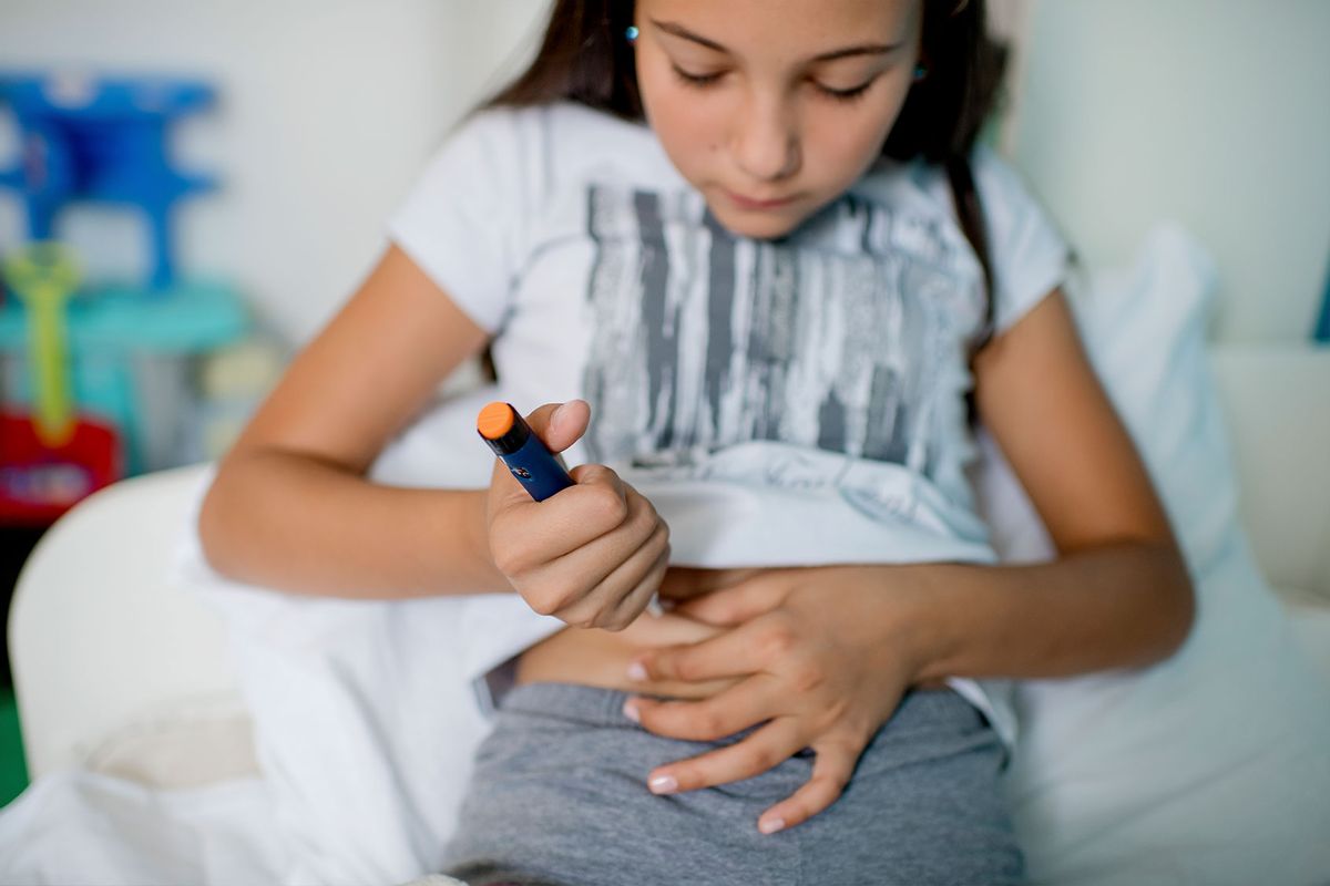 Diabetic girl injecting insulin in her stomach (Getty Images/dmphoto)