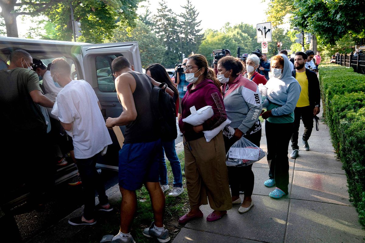 Migrants from Venezuela, who boarded a bus in Texas, wait to be transported to a local church by volunteers after being dropped off outside the residence of US Vice President Kamala Harris, at the Naval Observatory in Washington, DC, on September 15, 2022. (STEFANI REYNOLDS/AFP via Getty Images)