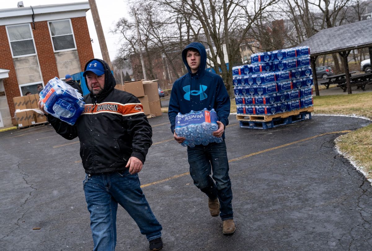 Shawn Mitchell and Braden Cianni volunteer to distribute cases of water to residents on February 17, 2023 in East Palestine, Ohio. (Michael Swensen/Getty Images)