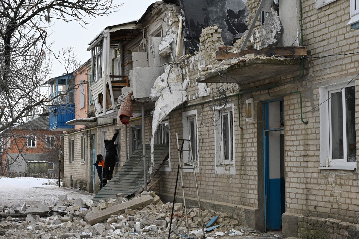 Local residents remove their belongings from a residential building that was partially destroyed as a result of Russian shelling in Kupiansk, Kharkiv region, Ukraine, Feb. 13, 2023. (Sergey Bobok/AFP via Getty Images)