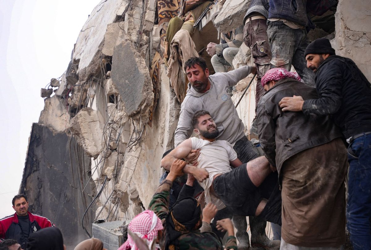 Residents retrieve an injured man from the rubble of a collapsed building following an earthquake in the town of Jandaris, in the countryside of Syria's northwestern city of Afrin in the rebel-held part of Aleppo province, on February 6, 2023.  (RAMI AL SAYED/AFP via Getty Images)
