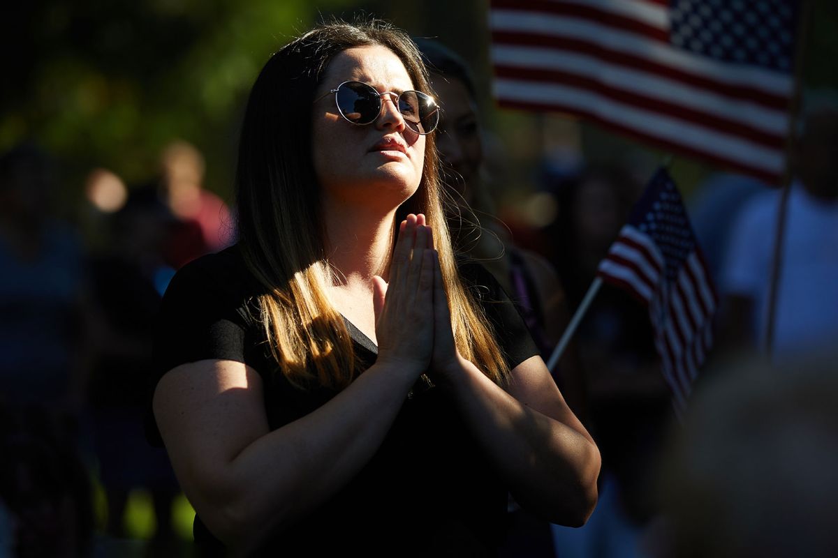 A woman prays as members and supporters of Patriot Prayer gather in Esther Short Park in Vancouver, Washington on September 5, 2020. (ALLISON DINNER/AFP via Getty Images)