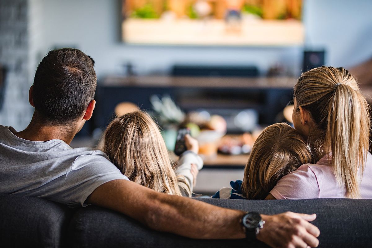 Family watching TV on sofa at home (Getty Images/skynesher)