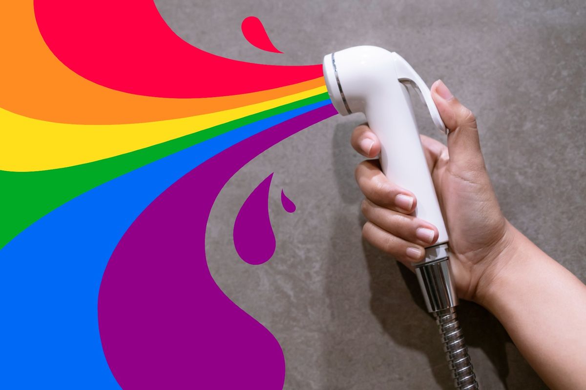 Female hand holding shower spray nozzle with rainbow pride color water cartoon graphic. (Biruoh/Getty)