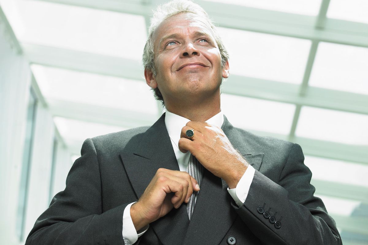 Mature businessman adjusting tie (Getty Images/Hans Neleman)