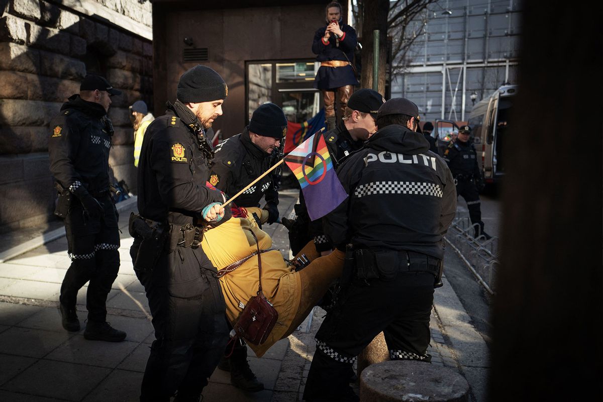 The Sami flag (C) is seen as police carry a Sami activist away, during a protest at the entrance of Norway's Ministery of Finance, in Oslo, on March 2, 2023. - On February 28, 2023, climate activist Greta Thunberg and dozens of indigenous Sami activists expanded a protest against contested wind turbines in Norway by blocking entrances to several government ministries. (OLIVIER MORIN/AFP via Getty Images)