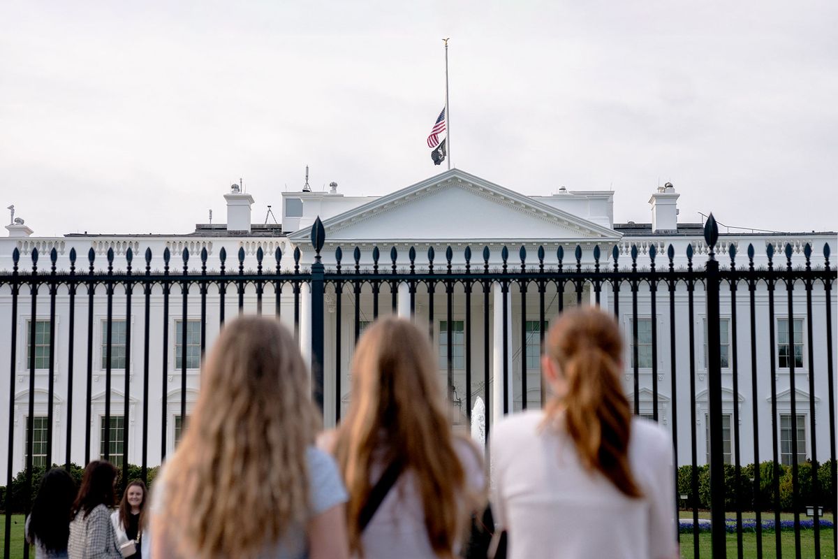 Visitors look as the US flag flies at half-mast on top of the White House in Washington, DC, on March 28, 2023, following a school shooting in Nashville, Tennessee, where three students and three staff members were killed on March 27. (STEFANI REYNOLDS/AFP via Getty Images)