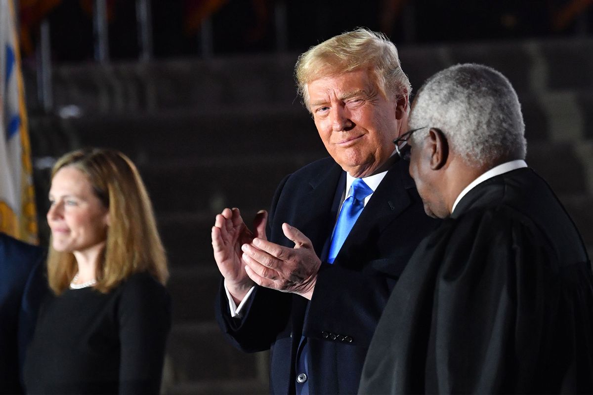 US President Donald Trump applauds next to Supreme Court Associate Justice Clarence Thomas during a ceremony on the South Lawn of the White House October 26, 2020, in Washington, DC. (NICHOLAS KAMM/AFP via Getty Images)