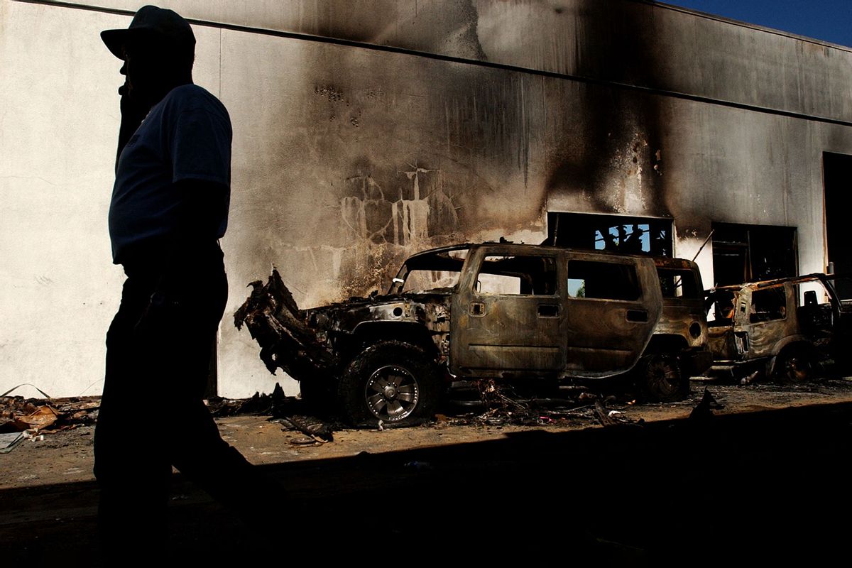 A contractor walks through Clippinger Chevrolet in West Covina Saturday morning August 23, 2003 where vandals torched and vandalized sport utility vehicles early Friday morning. (Sarah Reingewirtz/MediaNews Group/Los Angeles Daily News via Getty Images)