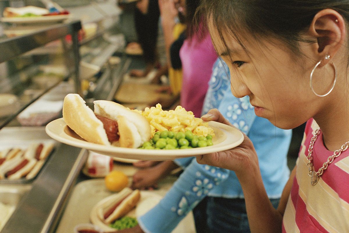 Young girl on lunch line, looking disappointedly at food (Getty Images/Yellow Dog Productions)