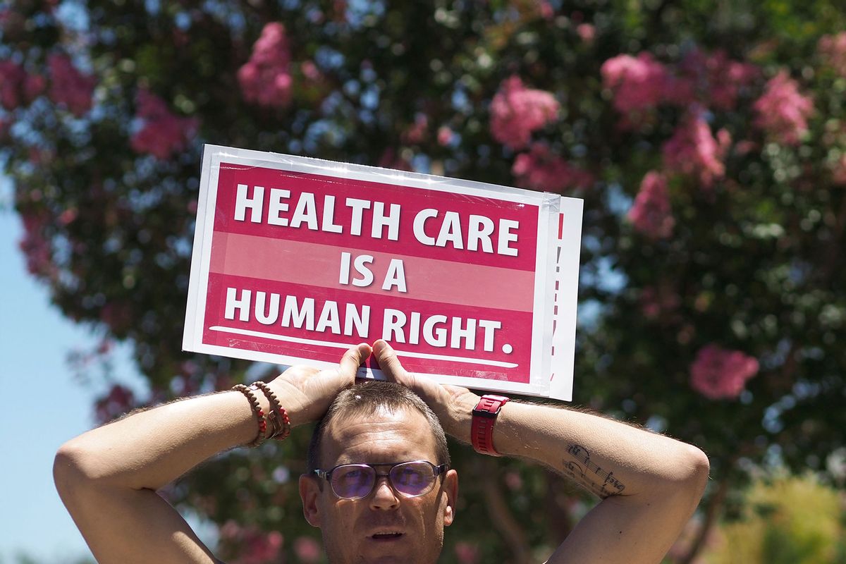 People rally in favor of single-payer healthcare for all Californians as the US Senate prepares to vote on the Senate GOP health care bill, outside the office of California Assembly Speaker Anthony Rendon, June 27, 2017 in South Gate, California. (ROBYN BECK/AFP via Getty Images)