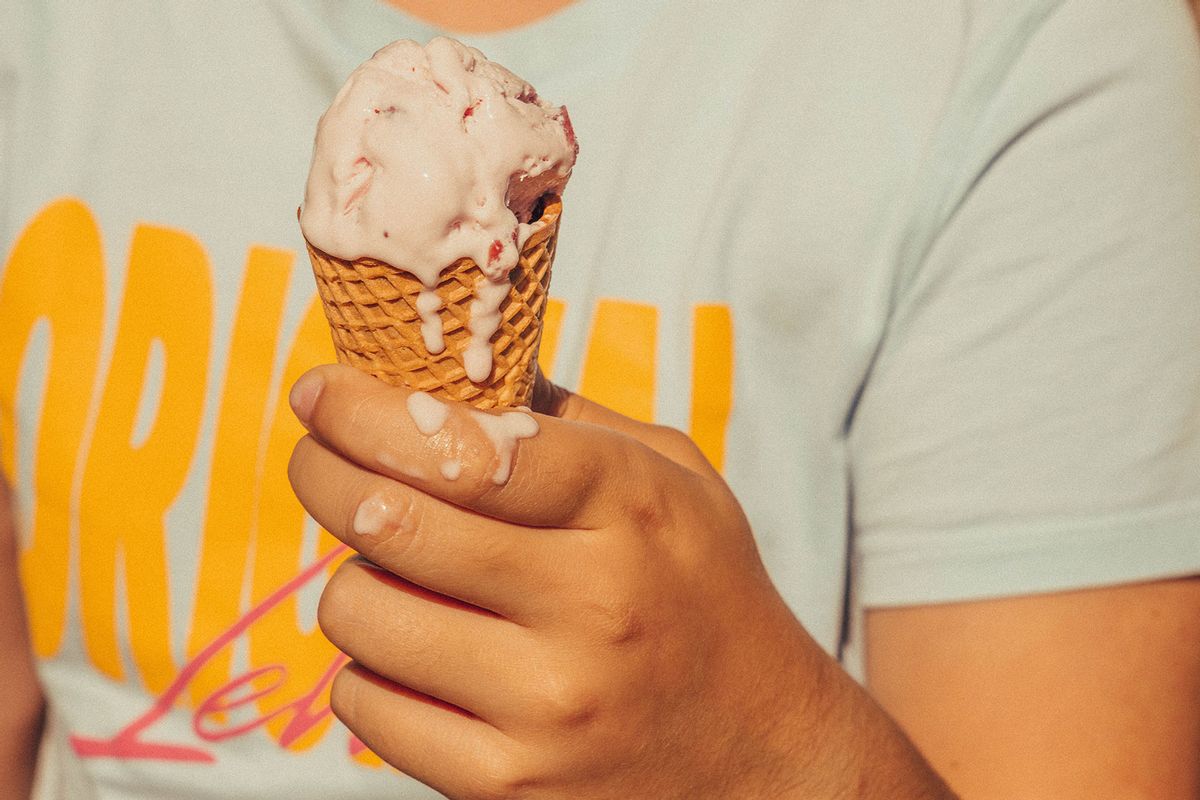 Kid holding ice cream cone melting in hot summer (Getty Images/Artur Debat)