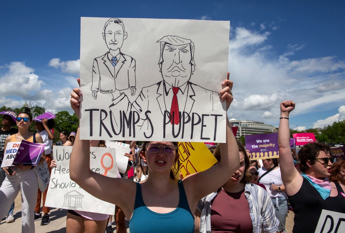 An abortion rights activist holds a sign with a sketch of Judge Matthew Joseph Kacsmaryk and former president Donald Trump while joining in a rally in support of abortion rights.  (Probal Rashid/LightRocket via Getty Images)