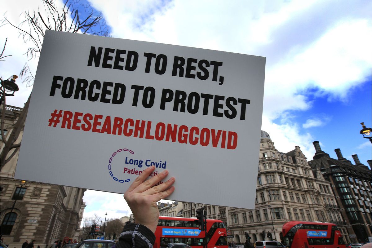 A protester holds up a placard demanding research into Long Covid-19 during the demonstration. (Martin Pope/SOPA Images/LightRocket via Getty Images)