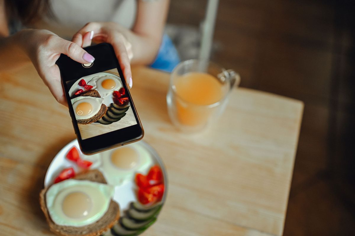 Food blogger using a smartphone to photograph breakfast (Getty Images/Netrebina Elena)