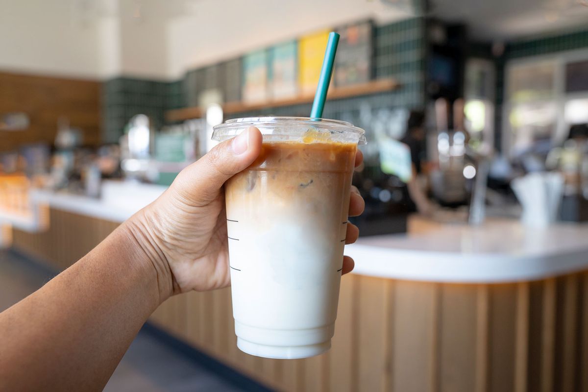 Holding a drink at a cafe (Getty Images/Virojt Changyencham)