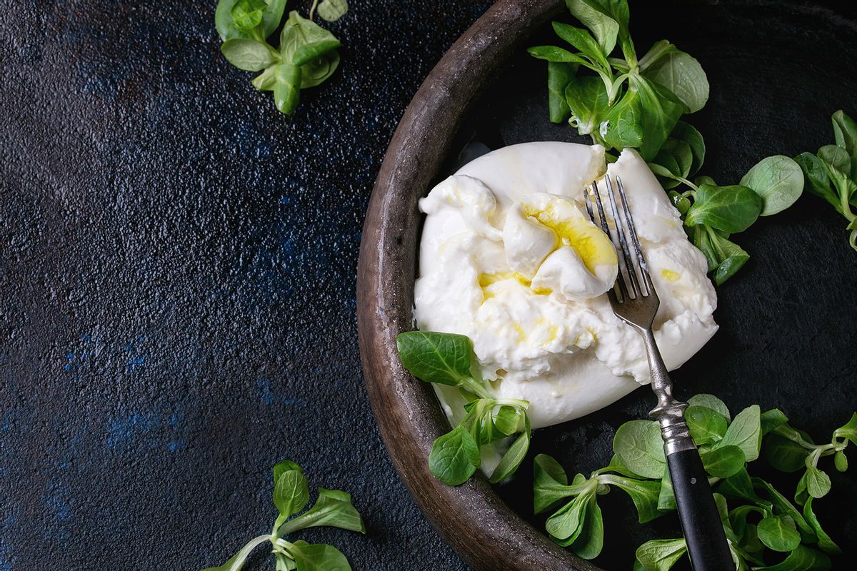 Sliced Italian cheese burrata with vintage fork, fresh corn salad and olive oil (The Picture Pantry/Getty Images)