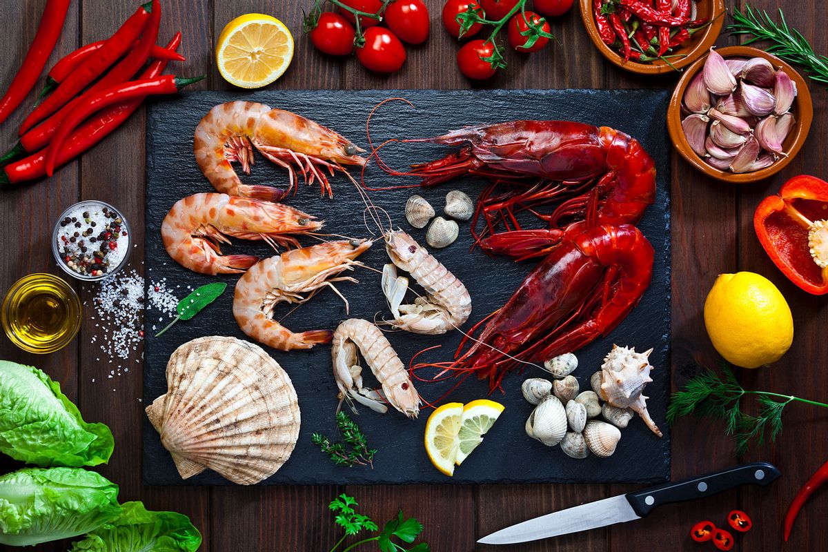 Mollusks and crustaceans ready for cooking on a wood kitchen counter top. (Getty Images/fcafotodigital)