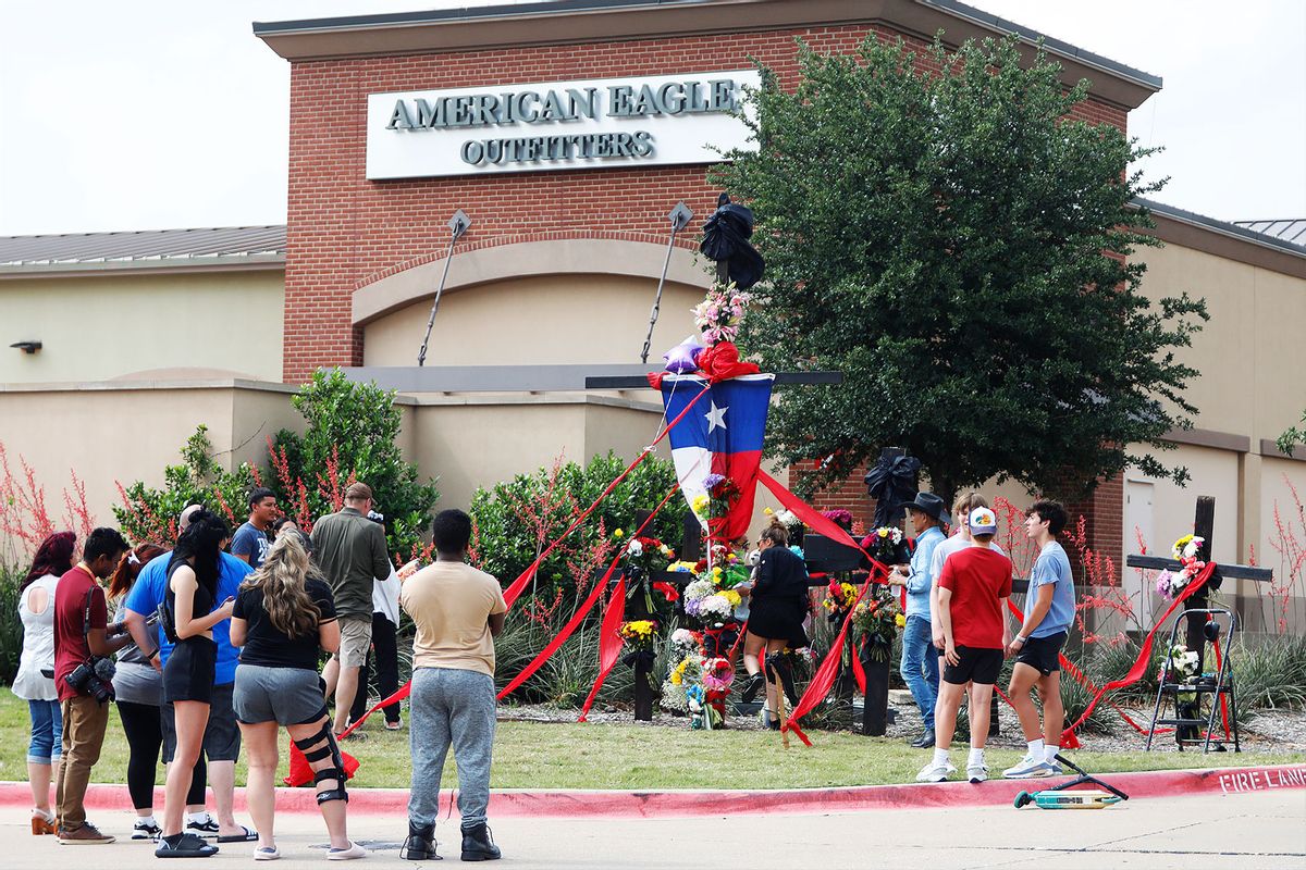 People watch as the construction of a wooden cross memorial is completed at the site of a fatal mass shooting a day earlier at Allen Premium Outlets on May 7, 2023 in Allen, Texas. (Stewart F. House/Getty Images)
