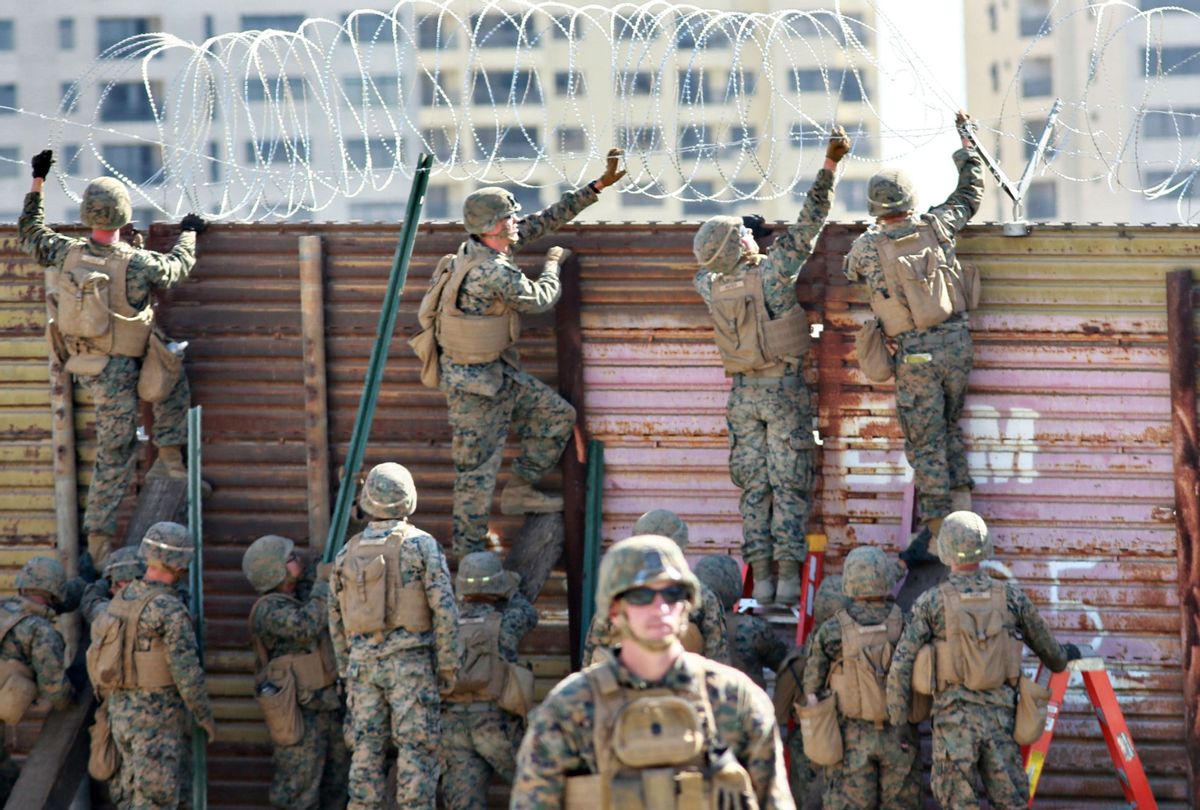 US marines put barbed wire atop fencing along the United States-Mexico border in San Ysidro, California, on November 9, 2018. (SANDY HUFFAKER/AFP via Getty Images)