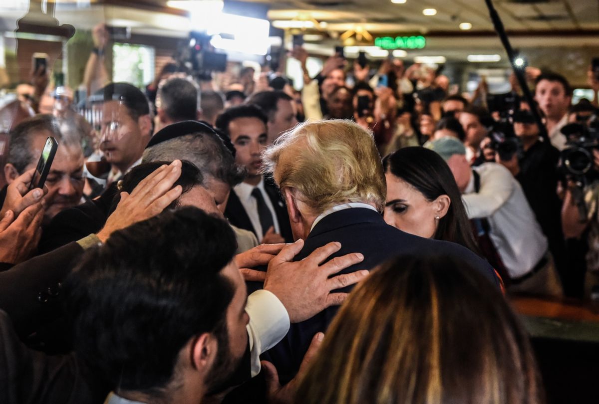 Former President Donald Trump prays with supporters as he visits the Versailles restaurant in the Little Havana neighborhood after being arraigned at the Wilkie D. Ferguson Jr. United States Federal Courthouse on June 13, 2023 in Miami, Florida.  (Stephanie Keith/Getty Images)