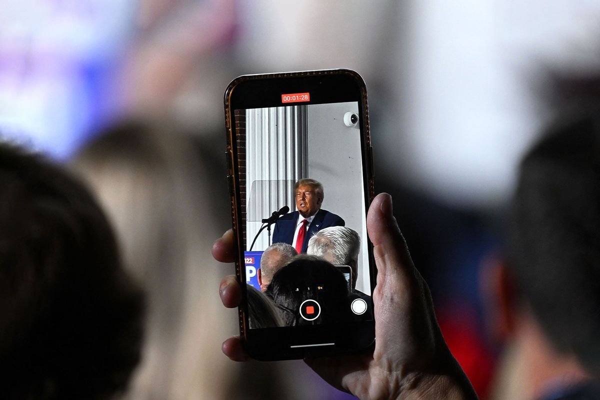 A person films former US President Donald Trump delivering remarks at Trump National Golf Club Bedminster in Bedminster, New Jersey, on June 13, 2023. (ED JONES/AFP via Getty Images)