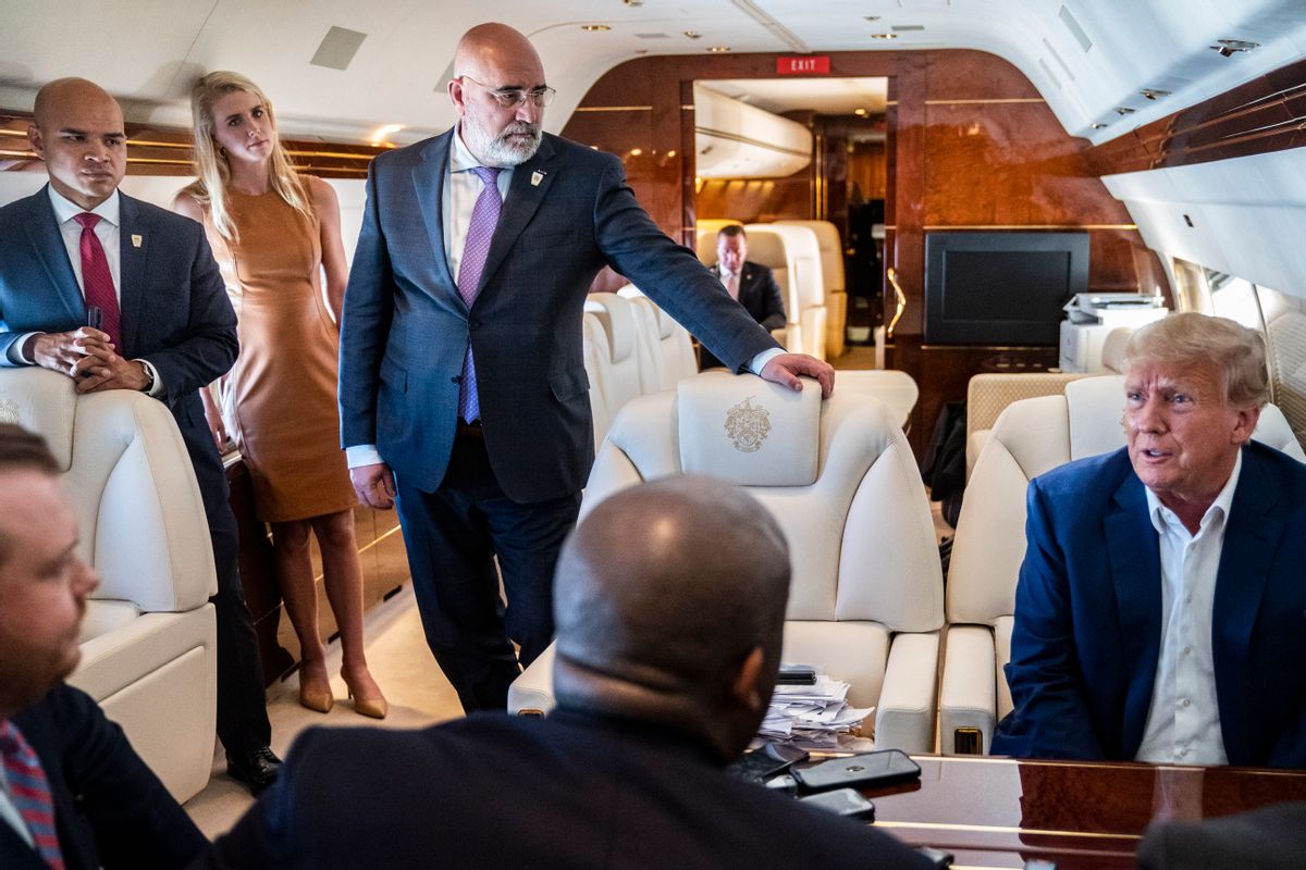 Walt Nauta, left, and Chris LaCivita, center, listen as former President Donald Trump speaks with reporters and staff on board "Trump Force One," March 13, 2023. (Jabin Botsford/The Washington Post via Getty Images)