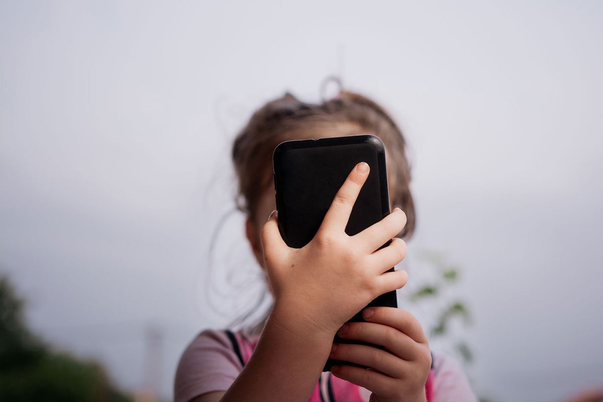 Little girl holding smartphone (Getty Images/Marizza)