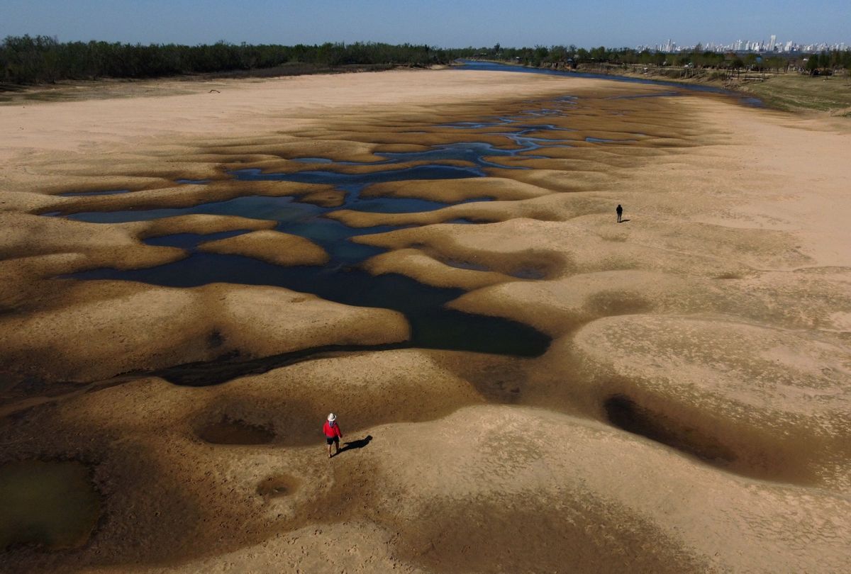 Aerial view of people walking along an almost dry arm of the Parana River, as water level reached a historic low, near Rosario, Santa Fe, Argentina. (JUAN MABROMATA/AFP via Getty Images)