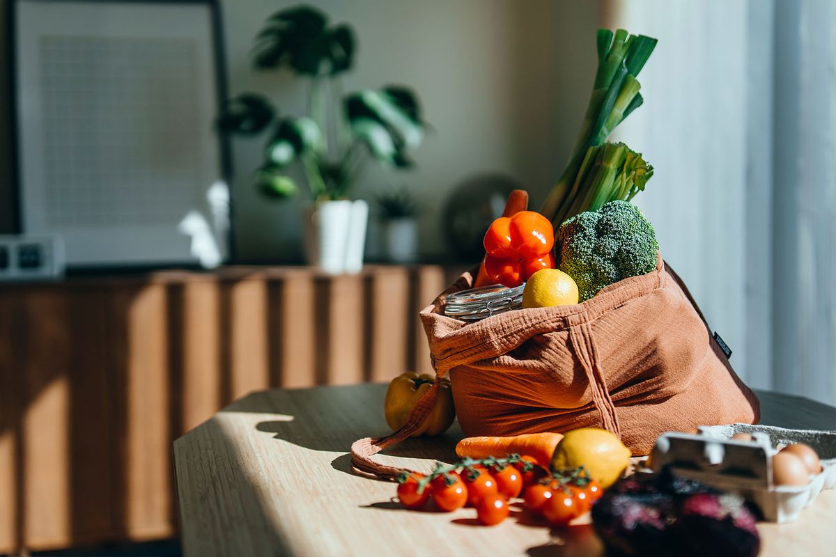 Shopping bag with multi-colored fresh vegetables and groceries on the table at home (Getty Images/d3sign)