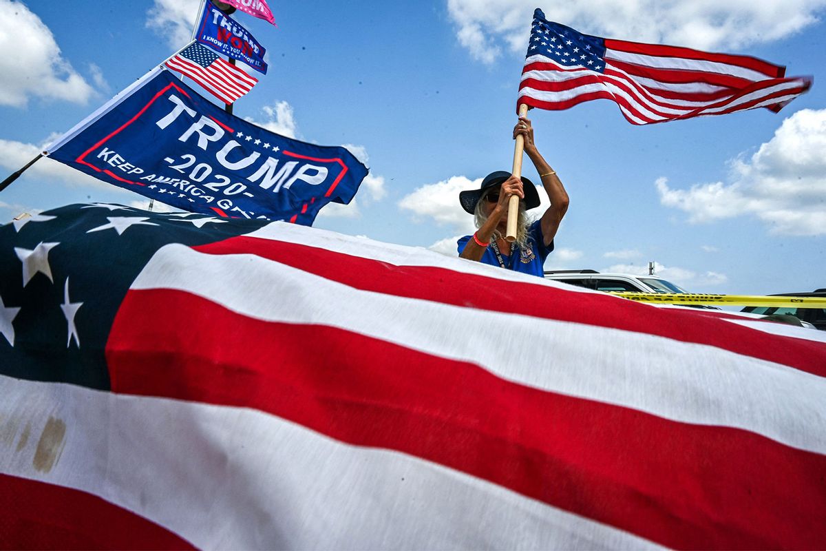 Supporters of former US President Donald Trump holds a US flag near Mar-a-Lago in Palm Beach, Florida, on April 2, 2023. (GIORGIO VIERA/AFP via Getty Images)